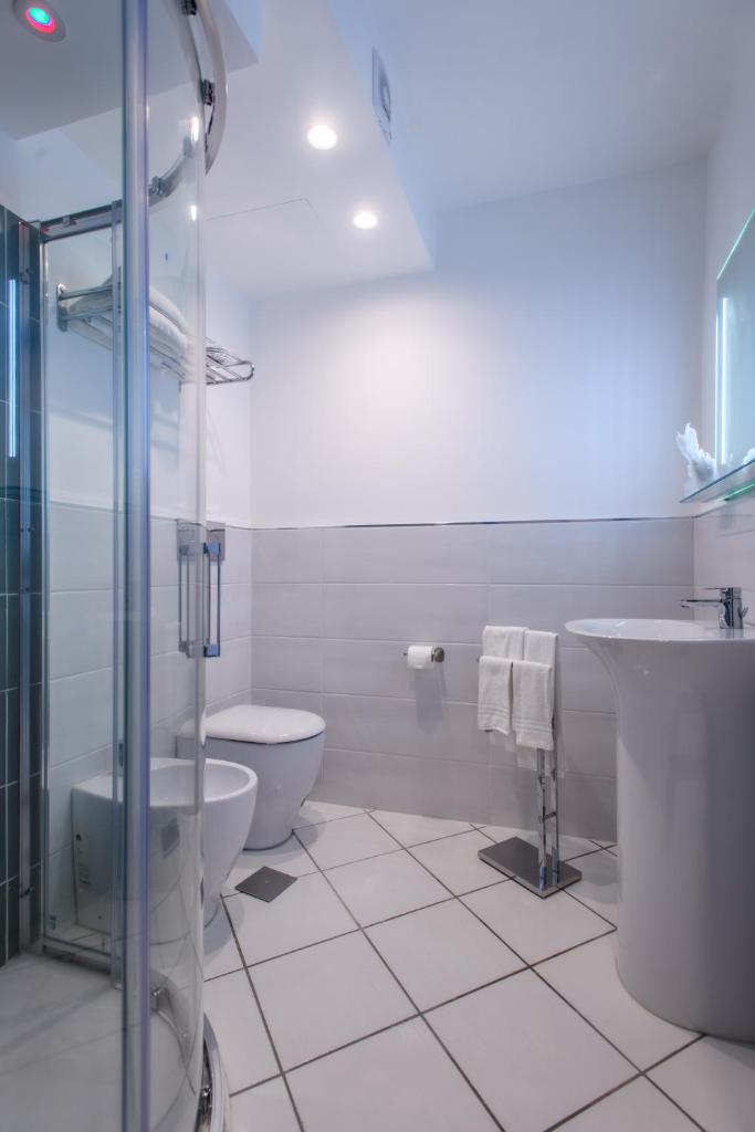 une salle de bain avec toilettes, lavabo et douche dans l'établissement Hotel Ancora, à Pontecagnano