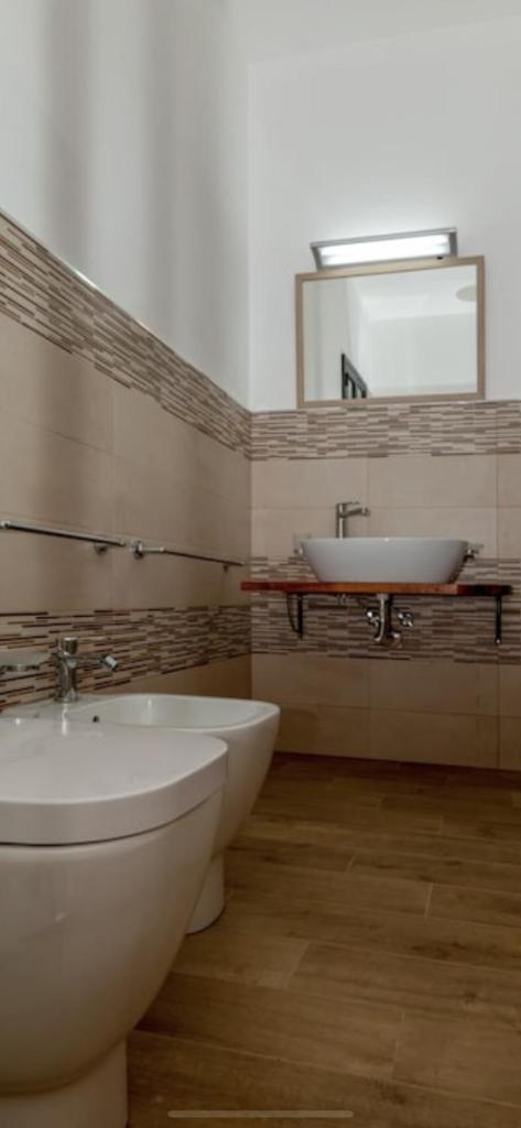 une salle de bain avec un lavabo, des toilettes et un miroir dans l'établissement Villas Sport And Beach, à Fanusa