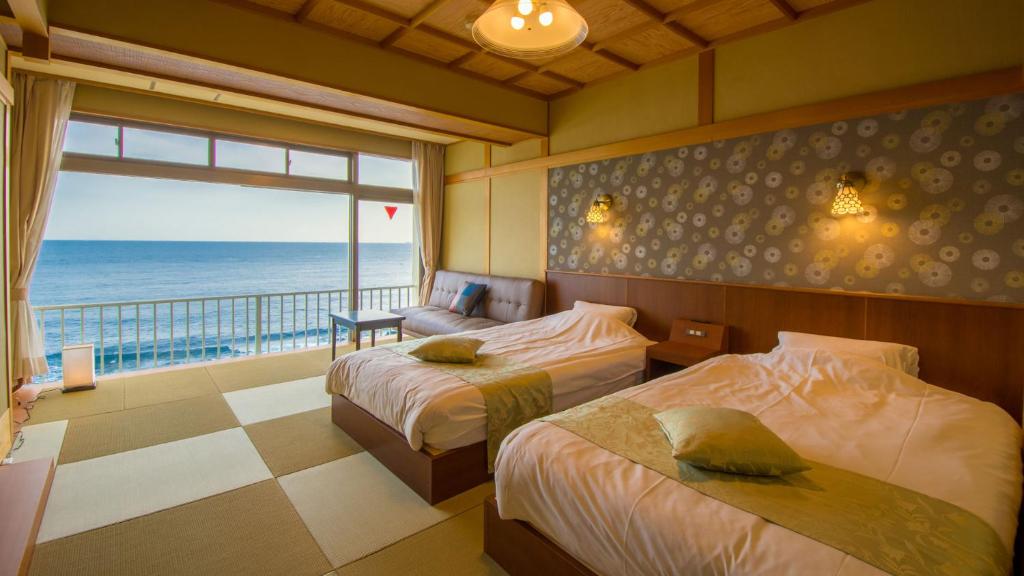 une chambre avec deux lits et une vue sur l'océan dans l'établissement Inatori Tokai Hotel Yuen, à Higashiizu 37 autres photos