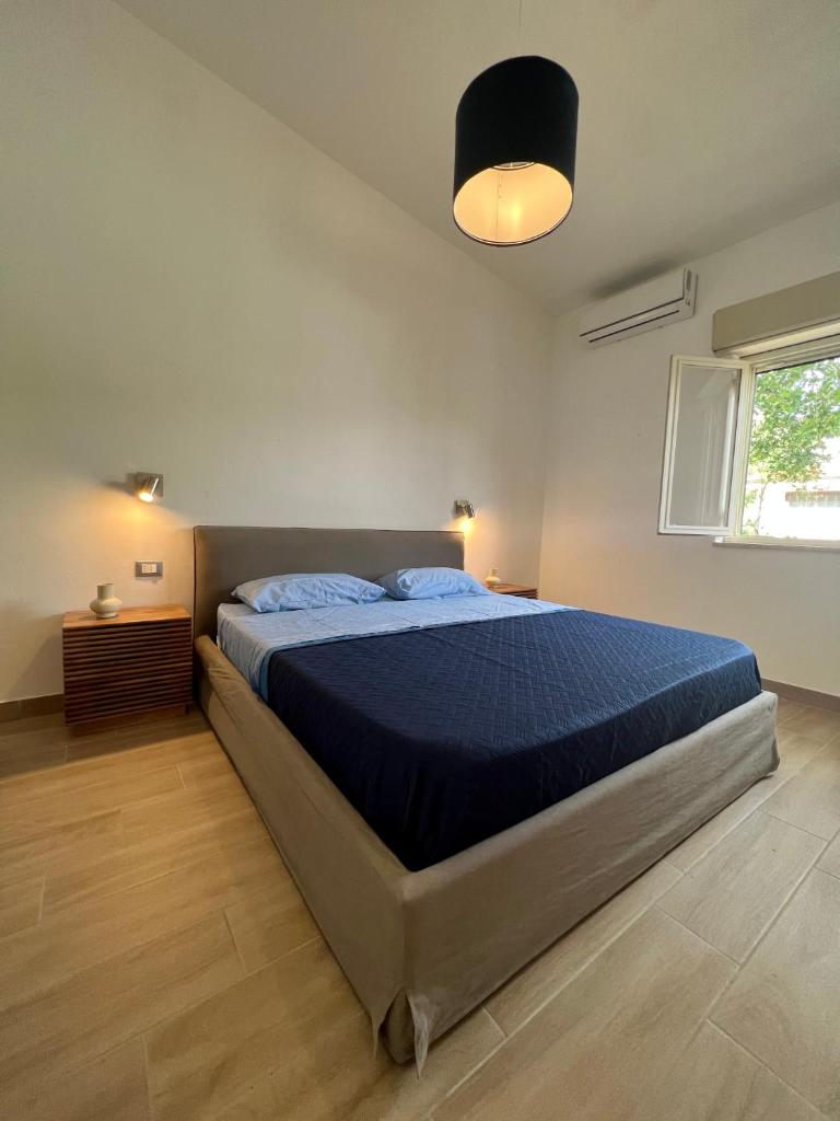 une chambre avec un grand lit avec une couverture bleue dans l'établissement Villa Paladino, à Ioppolo
