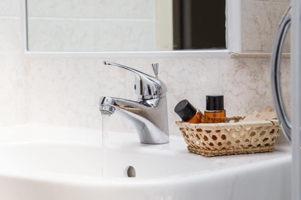 un évier avec un robinet et un panier de savon dans l'établissement Hotel Baltic, à Cesenatico