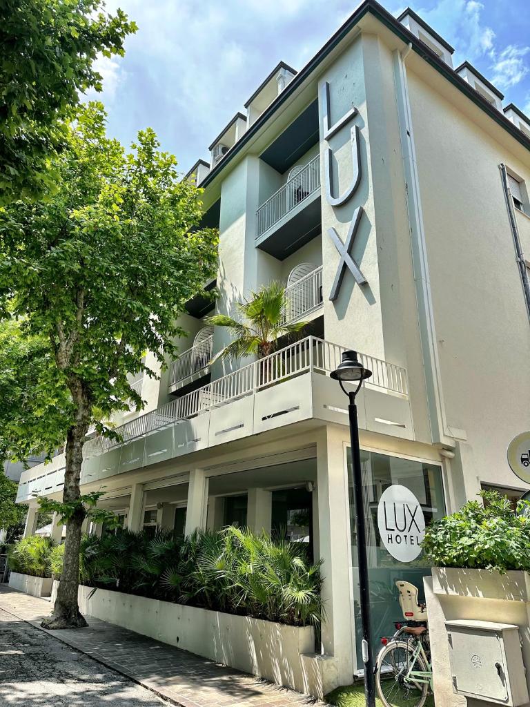 un bâtiment avec une grande horloge sur son côté dans l'établissement Hotel Lux, à Gabicce Mare