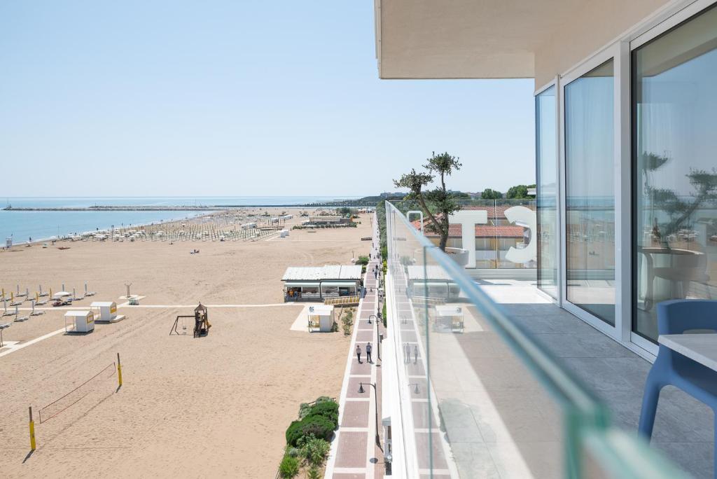 une vue sur la plage depuis le balcon d'un immeuble dans l'établissement Unico Hotel Caorle, à Caorle