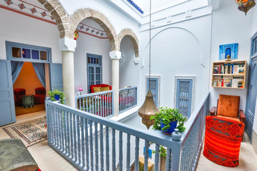 un couloir d'une maison avec des murs et des arches blancs dans l'établissement Riad Alech, à Essaouira