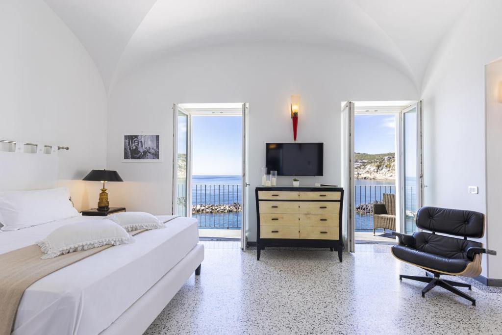 - une chambre avec un lit, une télévision et une chaise dans l'établissement Roccobarocco Boutique Hotel, à Ischia