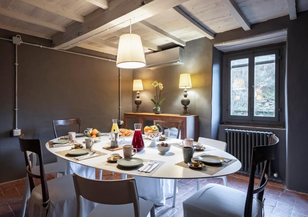 une salle à manger avec une table et des chaises blanches dans l'établissement Mulino Morandi, à Il Molinaccio