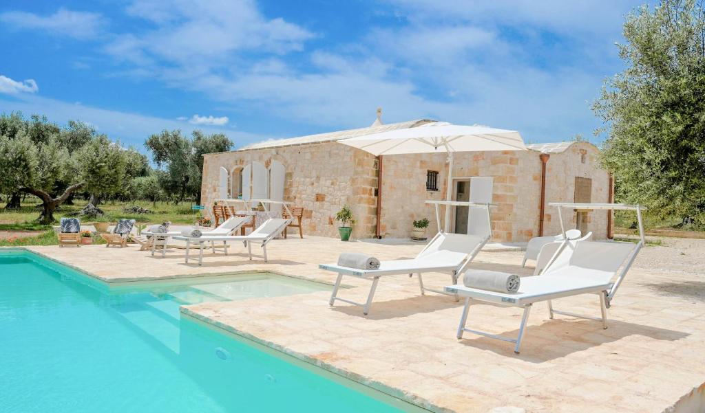 une villa avec piscine devant un immeuble dans l'établissement Trullo Delori with infinity Pool, à Villa Castelli