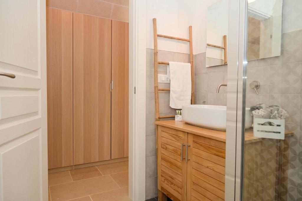 une salle de bain avec un lavabo et un miroir dans l'établissement Trullo Delori with infinity Pool, à Villa Castelli 37 autres photos