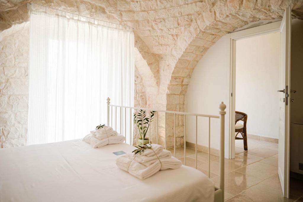 une chambre avec un lit avec des serviettes dessus dans l'établissement Trullo Delori with infinity Pool, à Villa Castelli