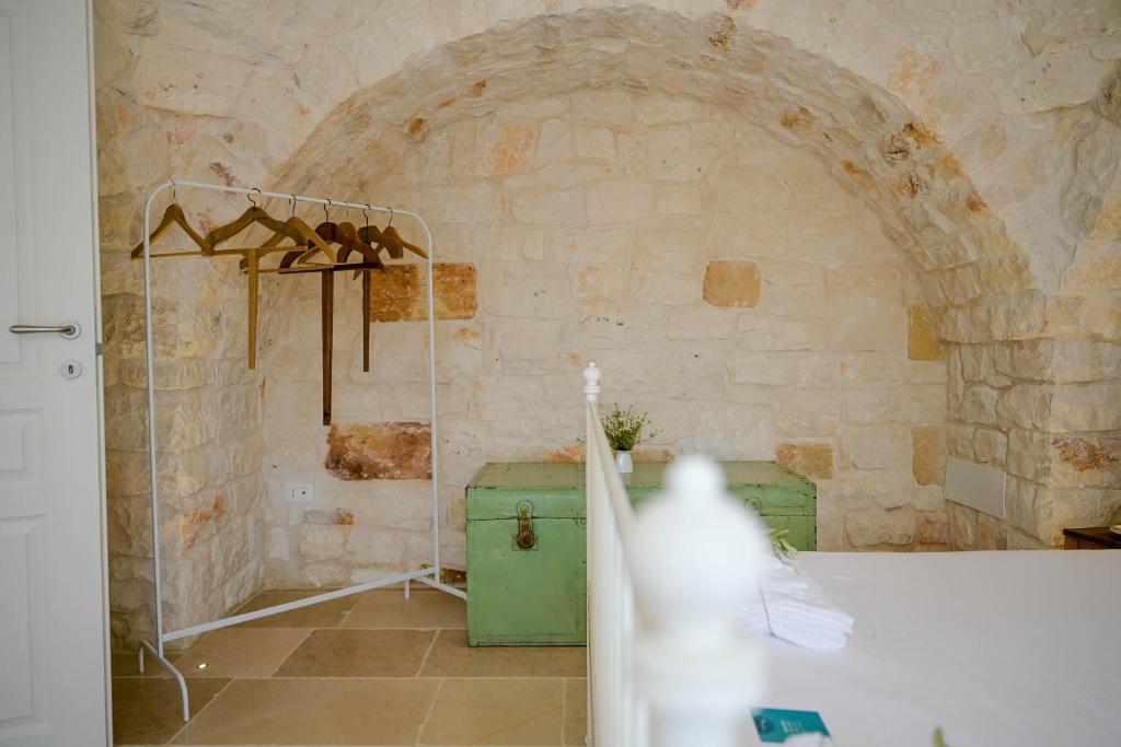 La salle de bains est pourvue d'un réfrigérateur vert et d'un mur en pierre. dans l'établissement Trullo Delori with infinity Pool, à Villa Castelli