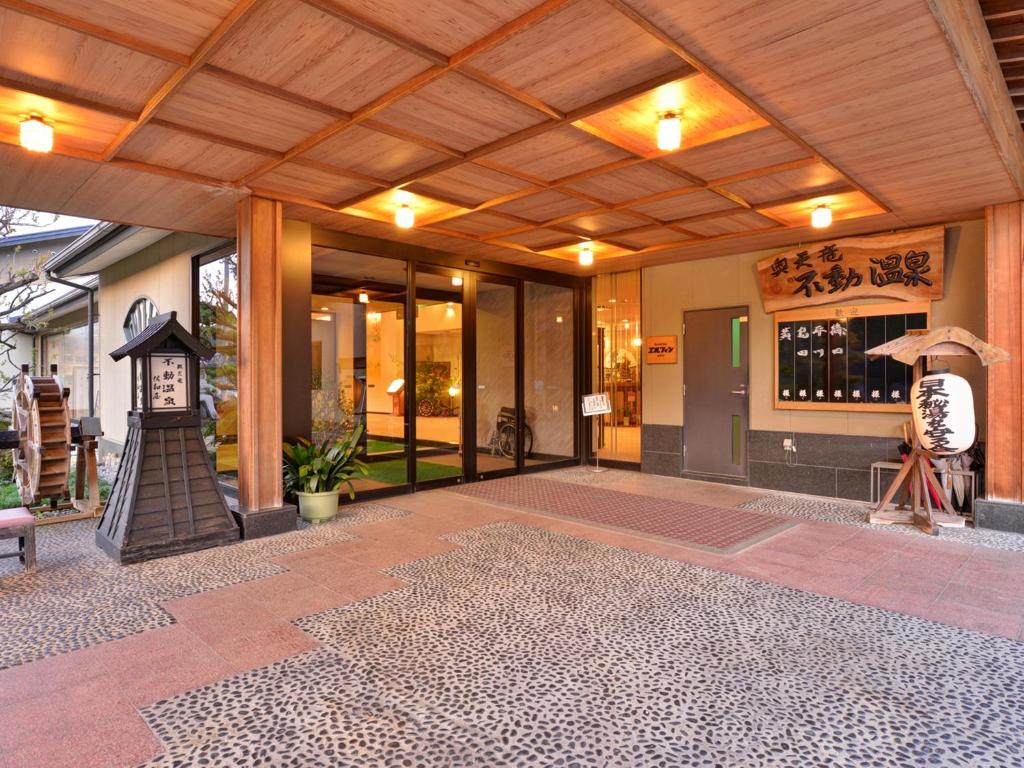 un bâtiment avec une horloge au milieu d'une terrasse dans l'établissement Fudouonsen Sawaya, à Shimojo mura