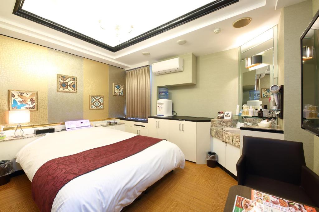 une chambre avec un grand lit et une cuisine dans l'établissement ホテルシエル湘南平塚店 - レジャーホテル -, à Hiratsuka