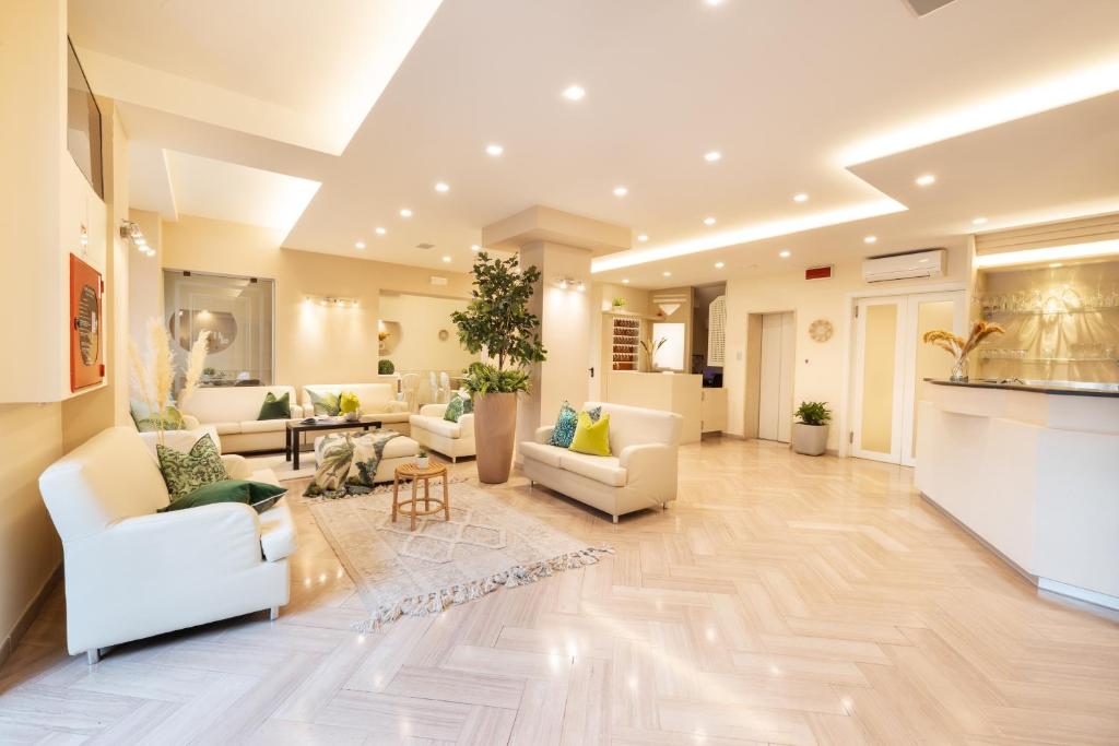 un grand salon avec des canapés blancs et des tables dans l'établissement Hotel Balaton, à Riccione