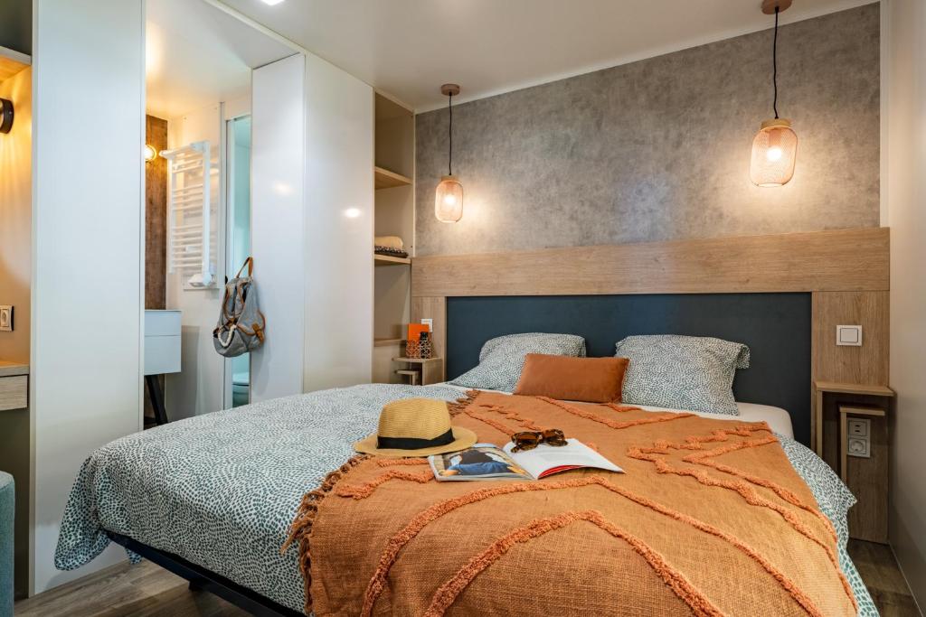 une chambre avec un lit avec un chapeau dessus dans l'établissement Camping Country Park Crecy La Chapelle - Site Officiel - Next to Disneyland Paris, à Crécy-la-Chapelle