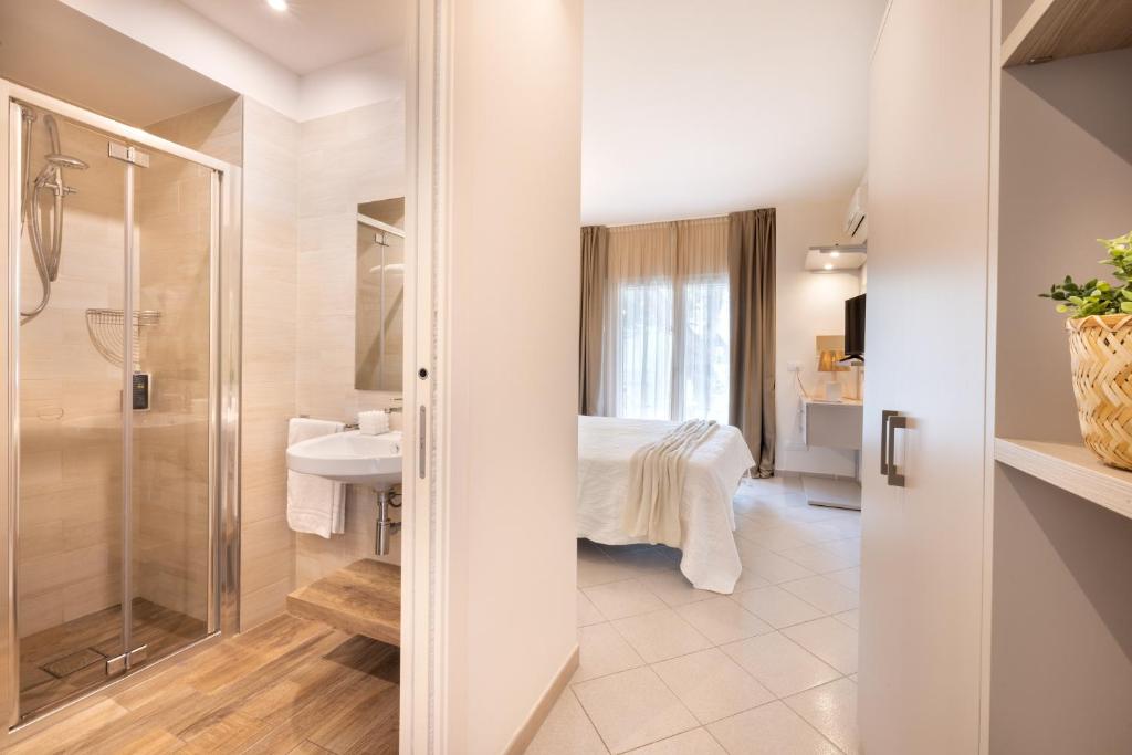 une salle de bain avec une douche et un lavabo et un lit dans l'établissement Hotel Balaton, à Riccione 144 autres photos