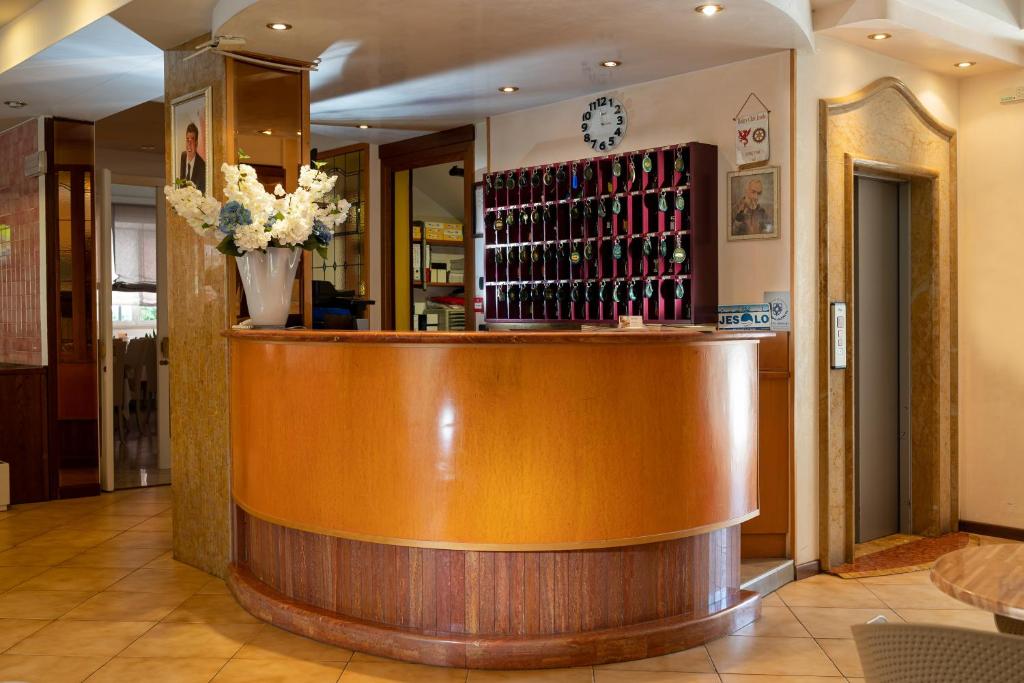 un bar dans un restaurant avec un vase de fleurs dans l'établissement Hotel Kennedy, à Lido di Jesolo