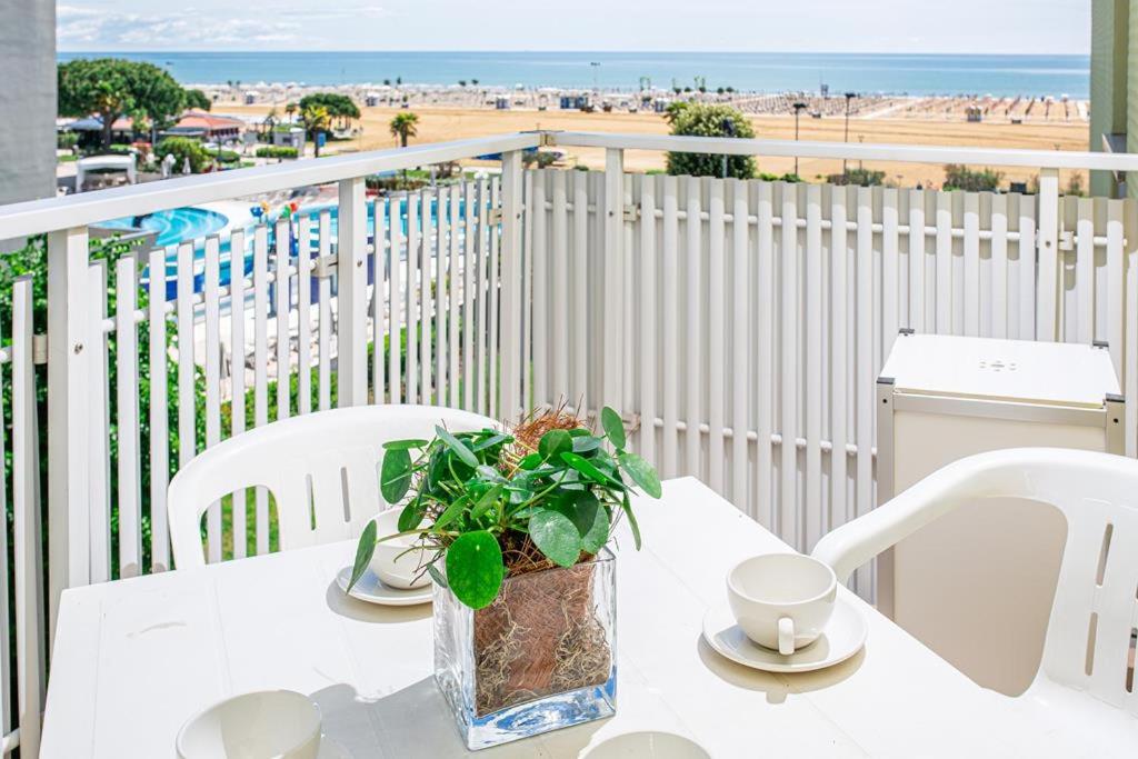 - une table blanche avec une plante sur un balcon donnant sur la plage dans l'établissement Appartamenti Aurora, à Bibione 17 autres photos