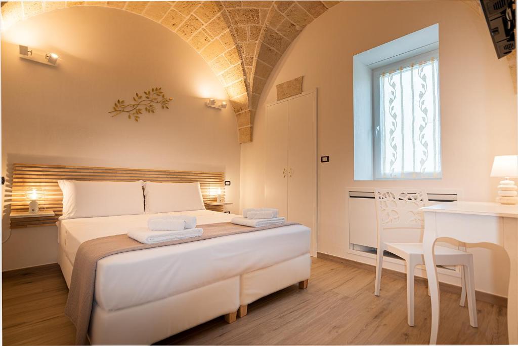 une chambre avec un grand lit blanc et une table dans l'établissement La Carezza del Sole - Private Villa, à Francavilla Fontana 61 autres photos