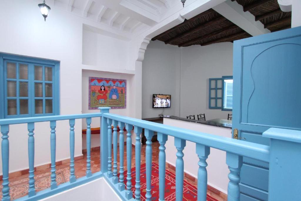 un escalier dans une maison avec une balustrade bleue dans l'établissement Dar Tranquille, à Essaouira