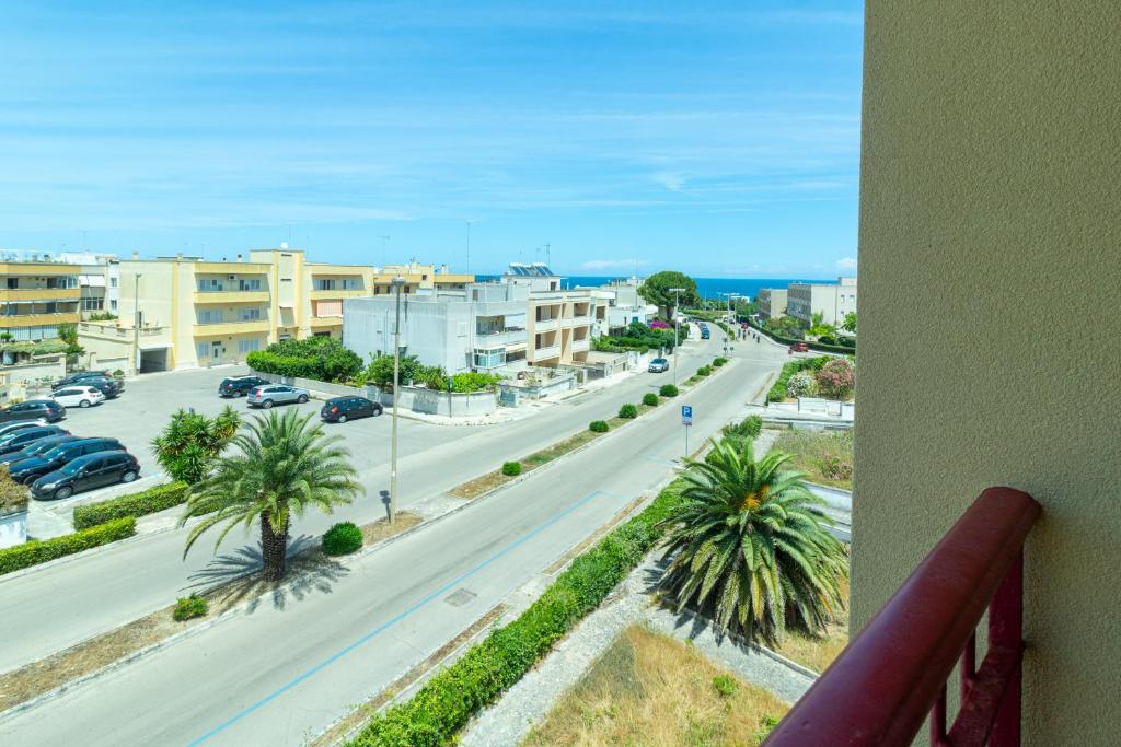 une vue depuis un balcon d'une rue avec des palmiers dans l'établissement Appartamenti Craulo, à Otrante