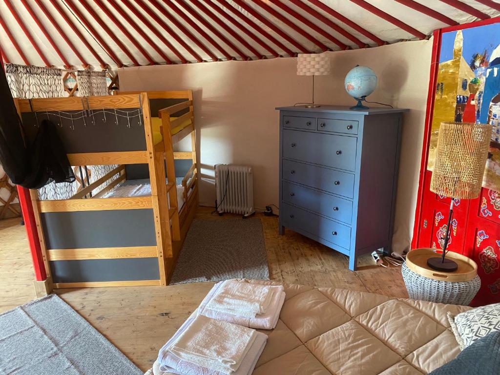 - une chambre avec des lits superposés et une commode dans l'établissement Yourte mongole, à Gignac