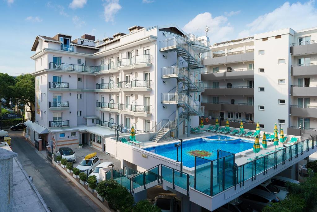 un immeuble d'appartements avec une piscine devant dans l'établissement Hotel Kennedy, à Lido di Jesolo