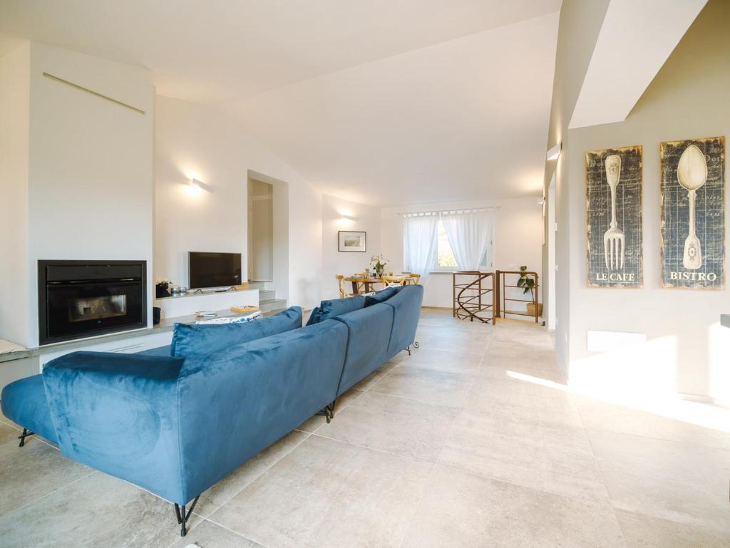 un salon avec un canapé bleu et une cheminée dans l'établissement Villa Astra, à Casale Marittimo