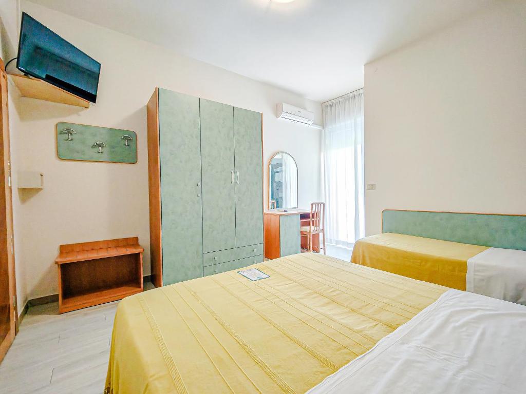 une chambre d'hôtel avec deux lits et une armoire verte dans l'établissement Hotel Rio Beach & Breakfast, à Cesenatico