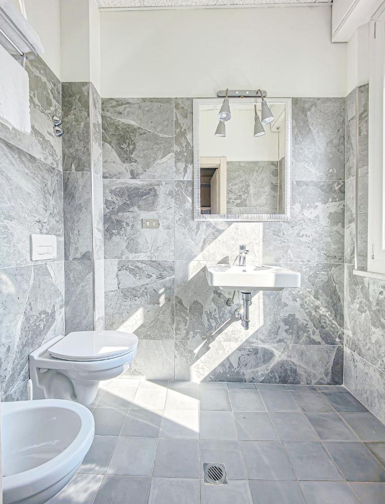 une salle de bain avec toilettes et lavabo dans l'établissement Hotel Rio Beach & Breakfast, à Cesenatico
