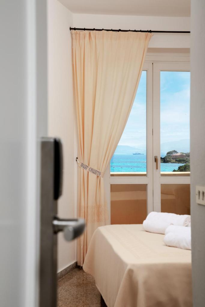 une chambre avec une fenêtre avec vue sur l'océan dans l'établissement Hotel Castello, à Golfo Aranci