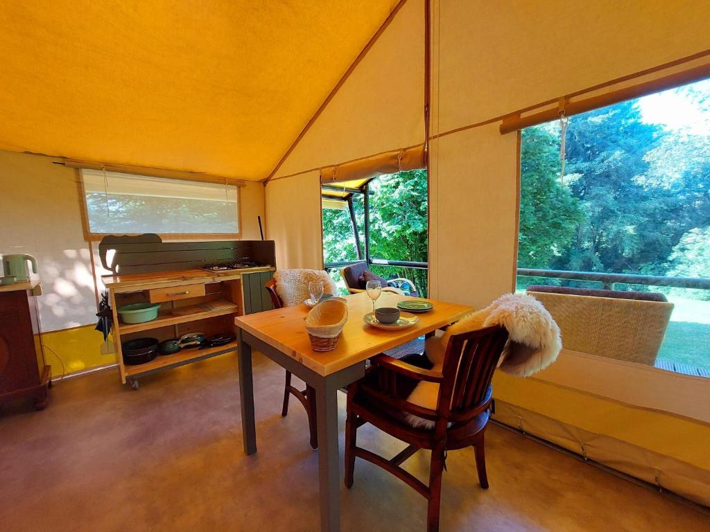 une salle à manger avec une table et des chaises dans une tente dans l'établissement Romantic Safari Tent Lodge, à Roussines 32 autres photos