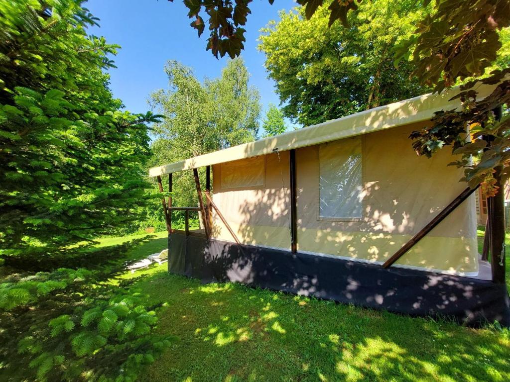 une cabane dans un champ d'herbe avec des arbres dans l'établissement Romantic Safari Tent Lodge, à Roussines