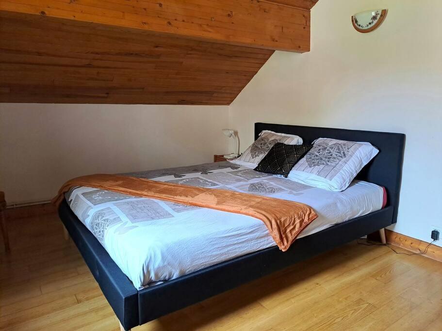 - un lit avec une couverture orange dans l'établissement Maison Landes - Gite 4 personnes, à Latouille-Lentillac