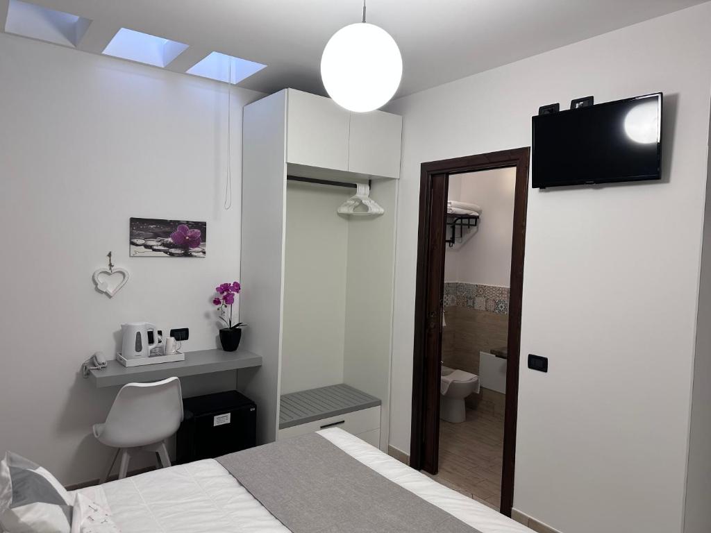 une chambre avec un lit, un bureau et un miroir dans l'établissement Hotel Baia Di Venere, à San Vito Lo Capo