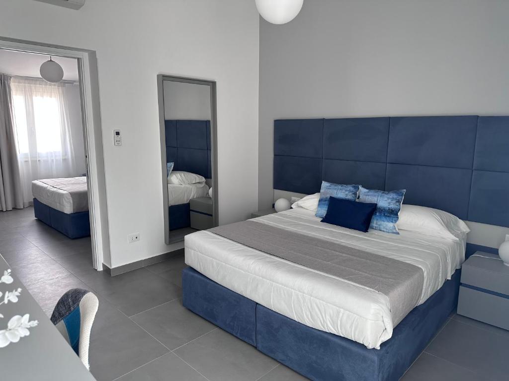 une chambre avec un grand lit et un miroir dans l'établissement Hotel Baia Di Venere, à San Vito Lo Capo