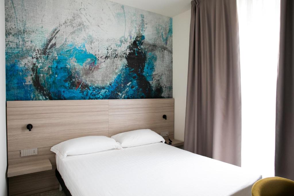 une chambre avec un lit et un tableau au mur dans l'établissement Hotel Cristallo, à Senigallia