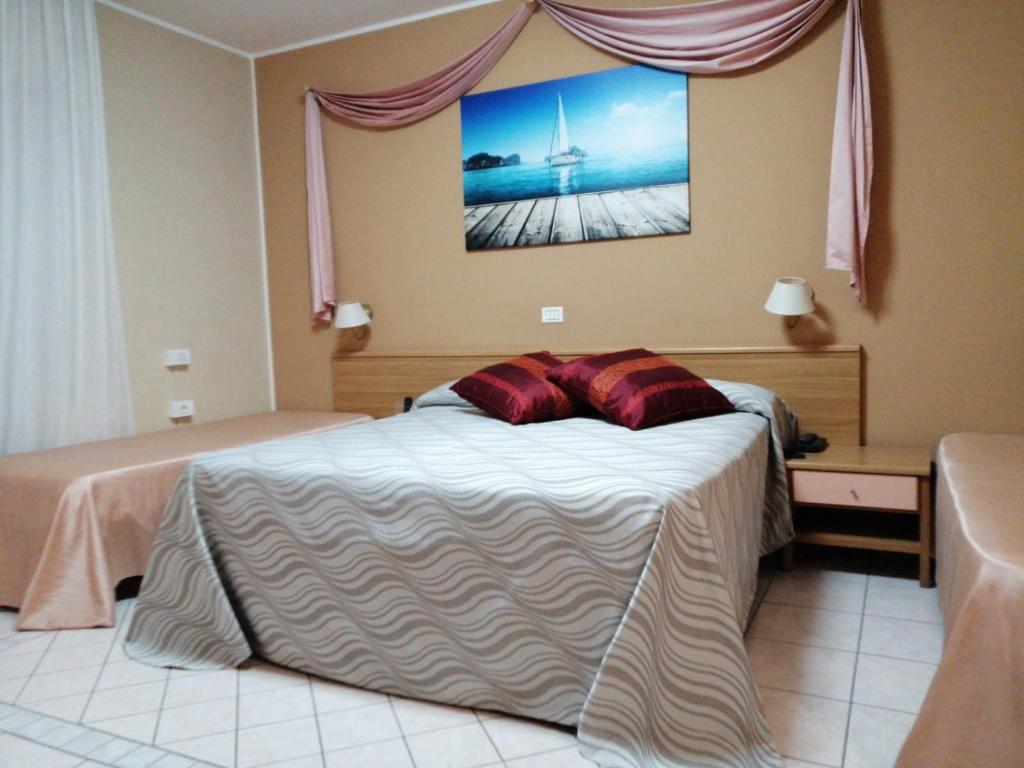 une chambre avec un lit avec des oreillers rouges dessus dans l'établissement Hotel Acquario, à Campomarino 46 autres photos