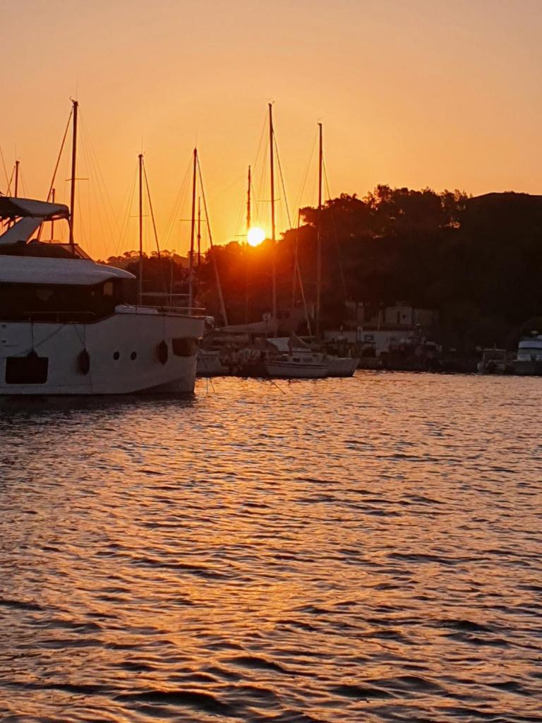 un groupe de bateaux dans l'eau au coucher du soleil dans l'établissement Porquerolles - Nuit insolite à bord du Défi Fou, à Porquerolles