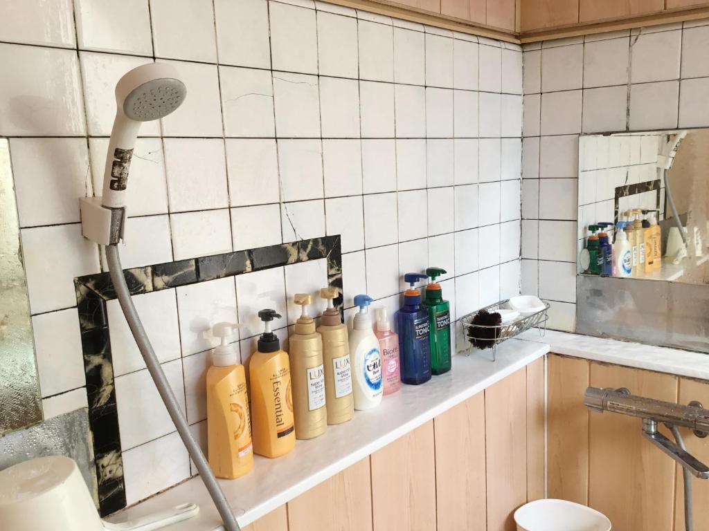 - une salle de bains pourvue d'une étagère avec des bouteilles dans l'établissement Fukushimakan, à Hakone