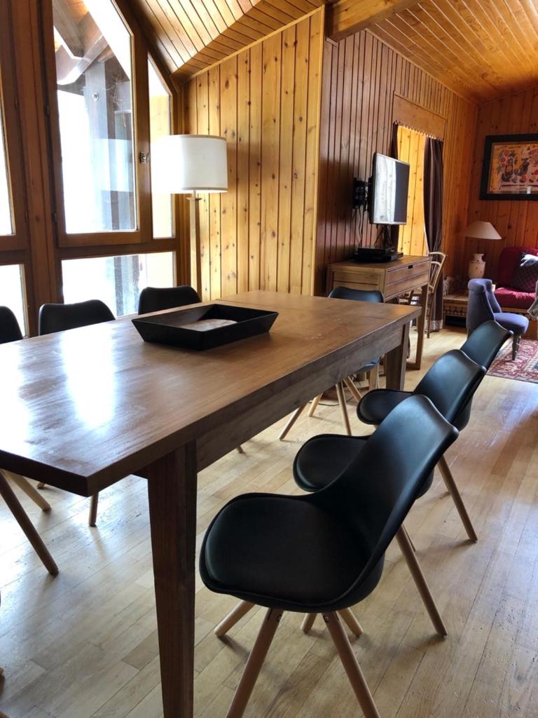 une salle à manger avec une table et des chaises en bois dans l'établissement L'Appart', à Les Deux Alpes