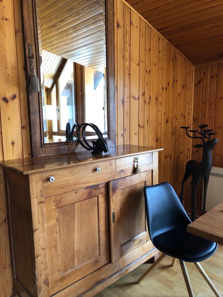 - un bureau en bois avec une chaise et un miroir dans l'établissement L'Appart', à Les Deux Alpes