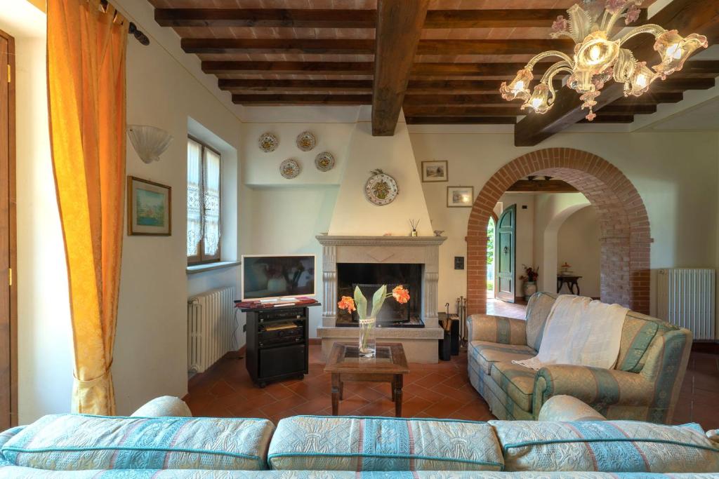 un salon avec un canapé et une cheminée dans l'établissement Experience the charm of Tenuta Le Caselle, a cozy farmhouse surrounded by nature and comfort!, à Subbiano