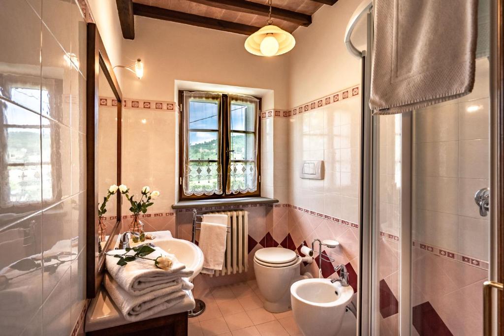 La salle de bains est pourvue de 2 lavabos, de toilettes et d'une douche. dans l'établissement Experience the charm of Tenuta Le Caselle, a cozy farmhouse surrounded by nature and comfort!, à Subbiano