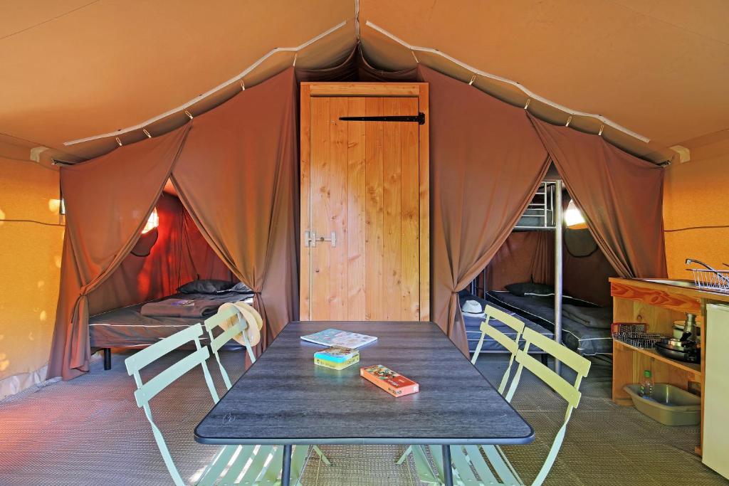 - une table et des chaises dans une chambre avec tente dans l'établissement Huttopia Millau, à Millau 17 autres photos