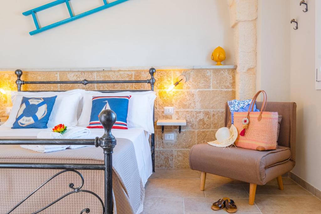 une chambre avec un lit et une chaise dans l'établissement Villa Malea Luxury - Otranto, à Giuggianello