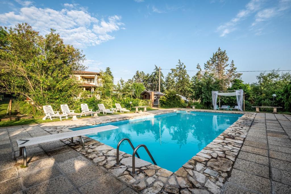 une piscine avec des chaises et une maison dans l'établissement Villa Santa Gabriella, à Casa Caviglieri