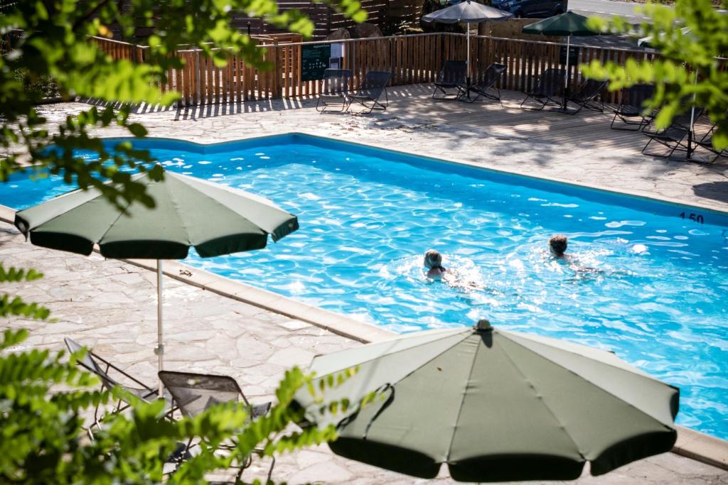 - une piscine avec parasols pour 2 personnes dans l'établissement Huttopia Gorges du Tarn, aux Vignes