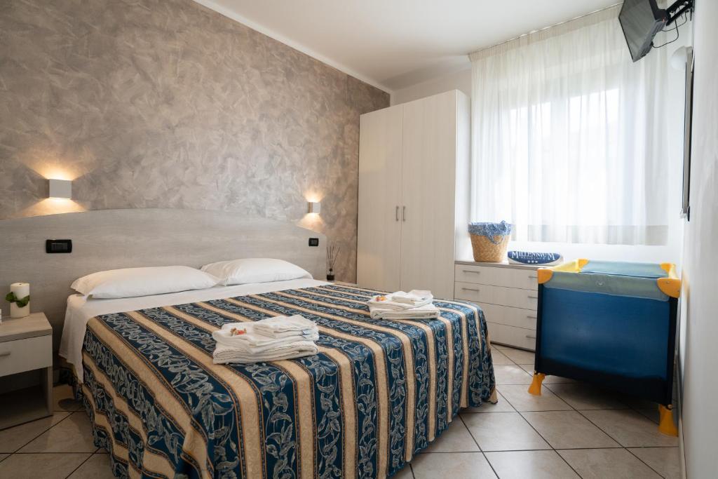 - une chambre avec un lit, une commode bleue et une fenêtre dans l'établissement Residence Millennium, à Rimini
