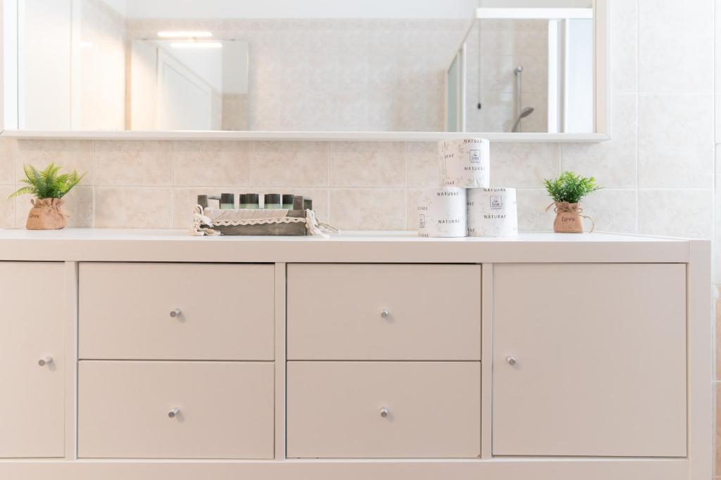une salle de bain blanche avec un lavabo et un miroir dans l'établissement Residence Millennium, à Rimini