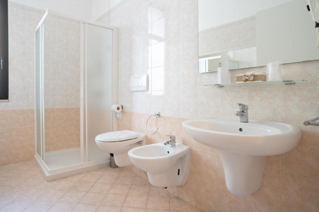 une salle de bain avec un lavabo, des toilettes et une douche dans l'établissement Residence Millennium, à Rimini 107 autres photos